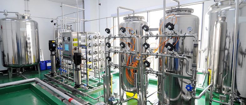 Stainless steel vessels, membrane housings and process pipework with instrumentation in a water treatment plant room.